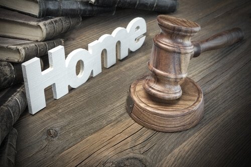 gavel and home sign on wooden surface