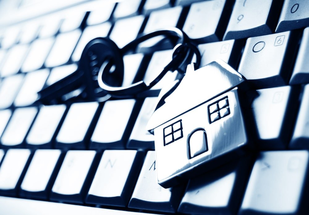 Online mortgage concept with keys and house-shaped key ring on laptop keyboard online mortgage companies