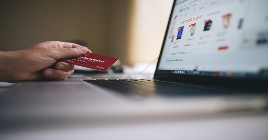 Experian credit report A woman at a computer gets her Experian credit report to prevent identity theft while shopping online.