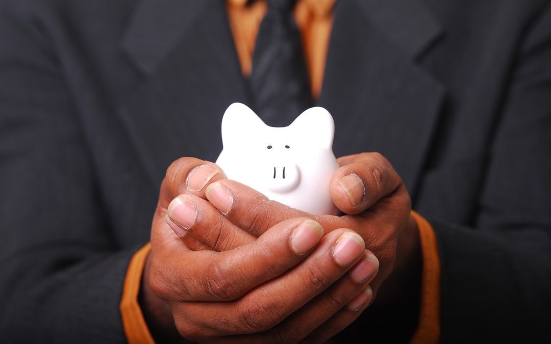man in suit holding a white piggy bank