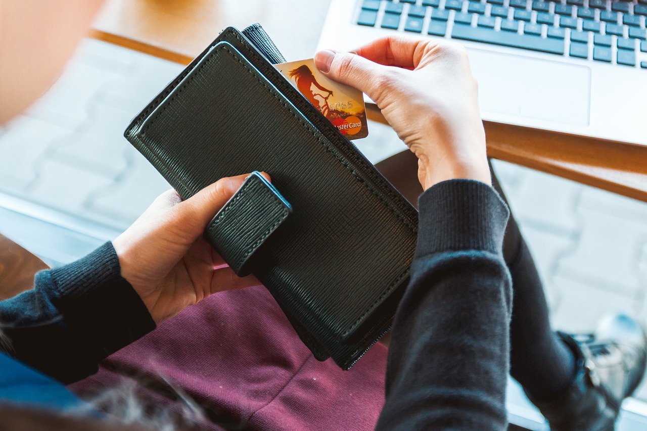 person checking a credit card on a wallet