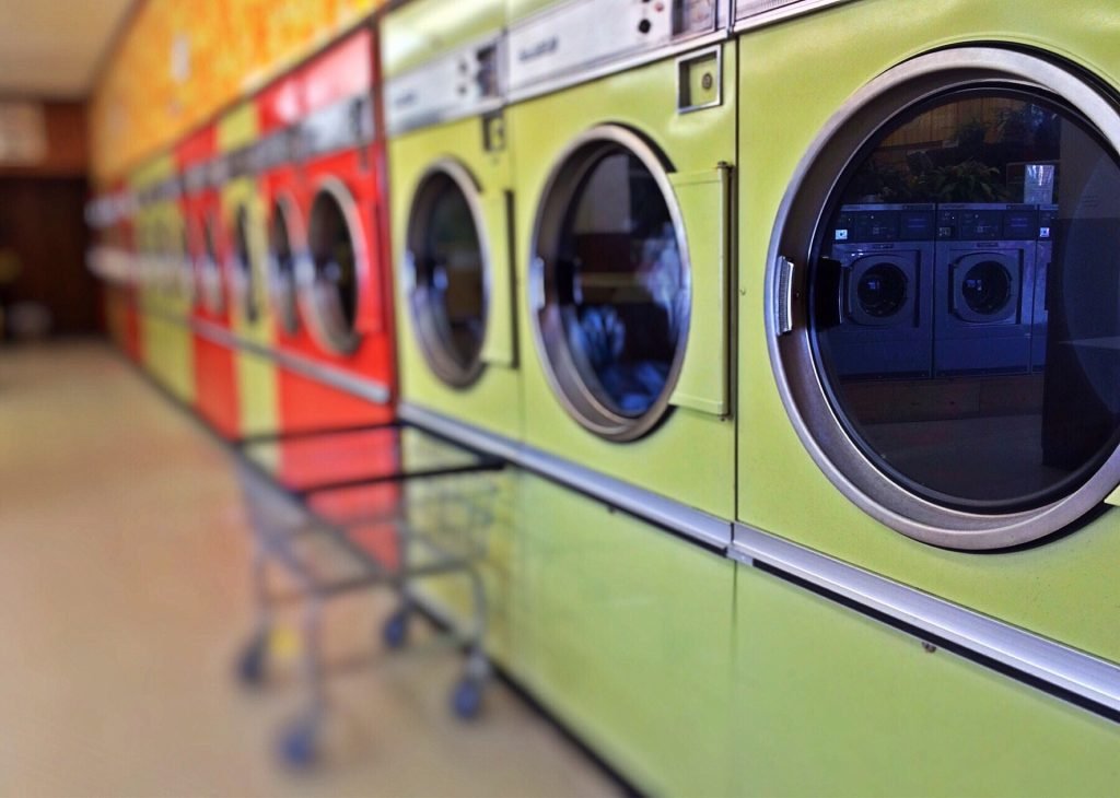 Different Colors of Laundry Machines and a Cart